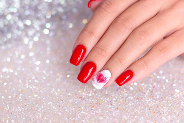 istock Female hand with red manicure nails, heart design 1301295647