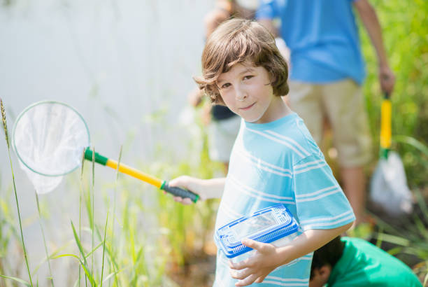 istock Caucasian boy exploring nature outdoors with a butterfly net 1301296897