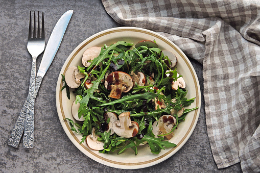 Vegan raw food recipe. Low-calorie Fitness salad with arugula and raw mushrooms.