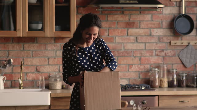 Woman opens parcel box checking ordered online goods feels satisfied