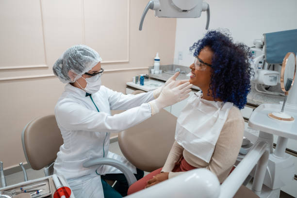 istock Dentist woman examines patient's mouth 1301303262