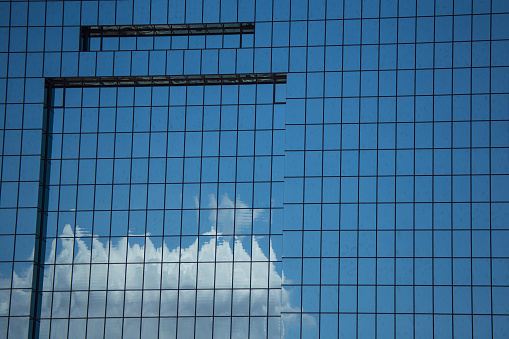 El Paso, Texas / USA - July 8, 2021: The blue sky and white clouds reflect off the Court House windows.
