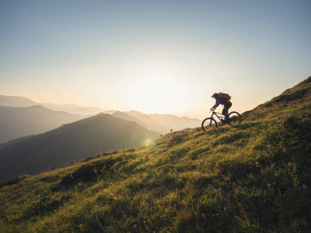 istock Mountain biker riding down a ridge line at sunset 1301308506
