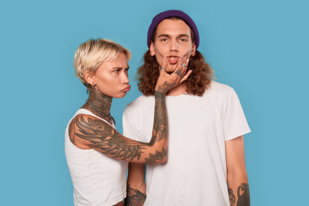 istock Funny woman touching man face, standing in studio 1301308784