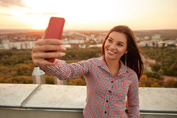 istock Happy woman taking selfie on rooftop 1301309156