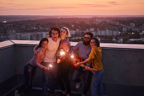 istock Happy friends with sparklers on rooftop in evening 1301309164