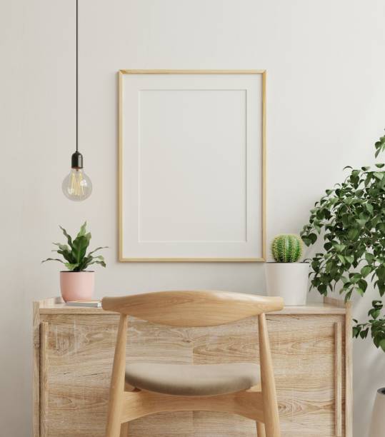 istock Mockup frame on work table in living room interior on empty white wall background. 1301310588