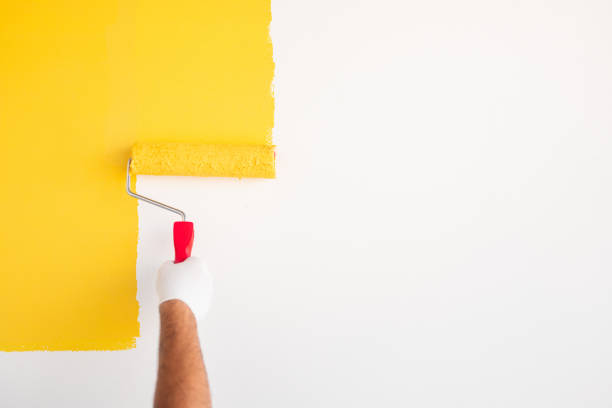 homme avec le mur de peinture de peinture de rouleau dans la couleur jaune - paint roller copy space action adult photos et images de collection