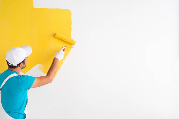 istock Unrecognizable man painting wall in yellow color 1301314275