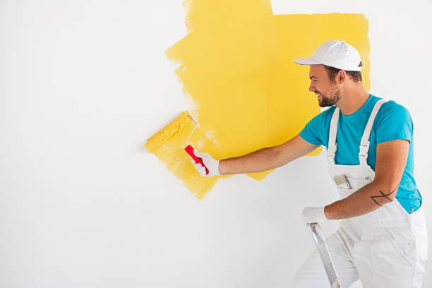 istock Worker painting wall in yellow color 1301314279
