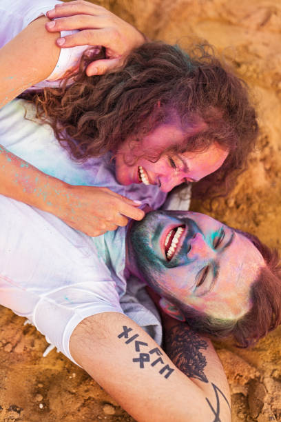 istock Delighted young couple hugging on sand during party 1301314317