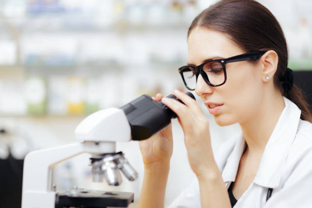 istock Female Scientist Looking through a Microscope in a Laboratory 1301315191