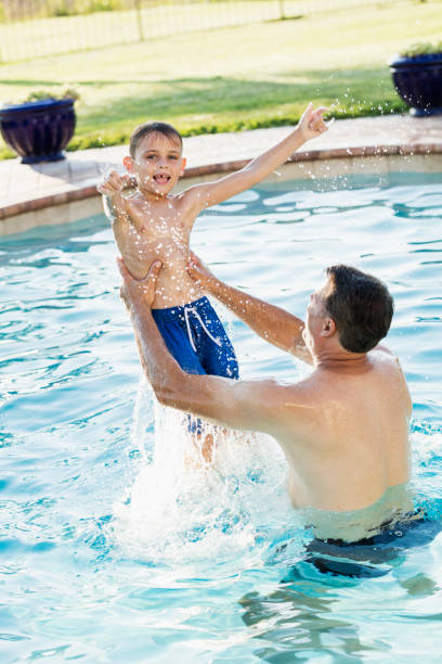 istock Father and son playing in pool 1301317399