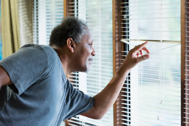 istock Senior man looking out the window 1301318410