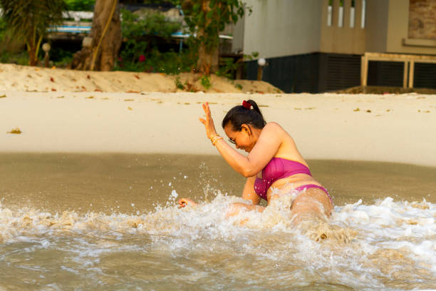 kobieta w bikini zadowolony z wody i fala na plaży - senior adult human face male action zdjęcia i obrazy z banku zdjęć