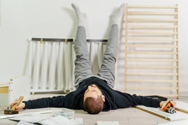 istock One man lying on the floor at home exhausted during self assembly project trying to put together DIY furniture devastated and desperate tired 1301322081