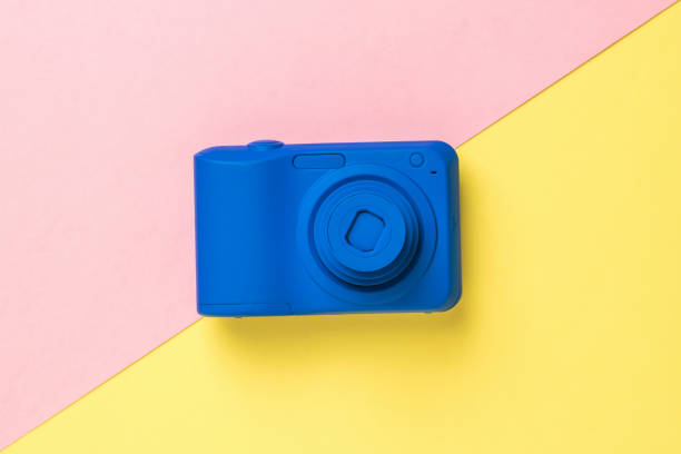 istock Top view of a blue camera on a yellow and pink background. 1301323006