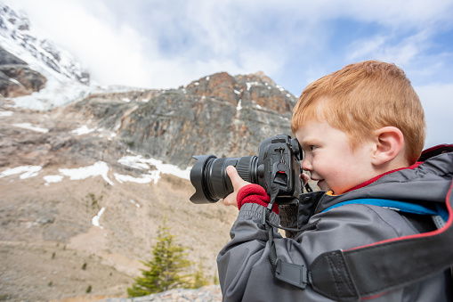 Young Boy Avalanche Watching and Taking Pictures at Mount Edith Cavell, Alberta, Canada