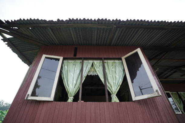 istock Old village window house with open frame mirror and rusty zinc roof 1301325473