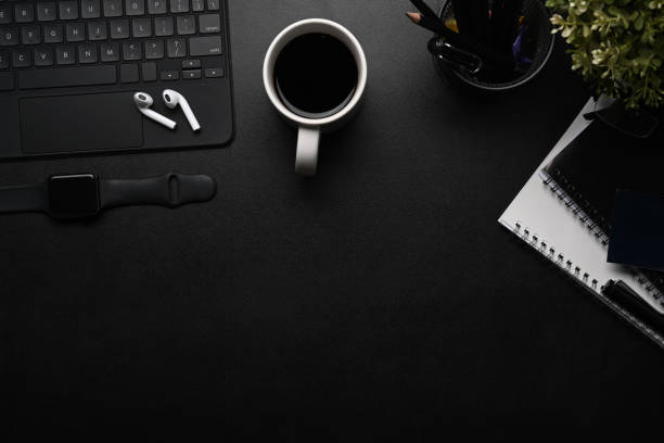 istock Top view of dark modern workspace with ireless earphone, smart watch, notebook, wireless keyboard and copy space. 1301325537