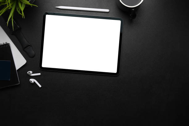 istock Mock up digital tablet with blank screen, stylus pen, wireless earphone and copy space on dark table. 1301325751