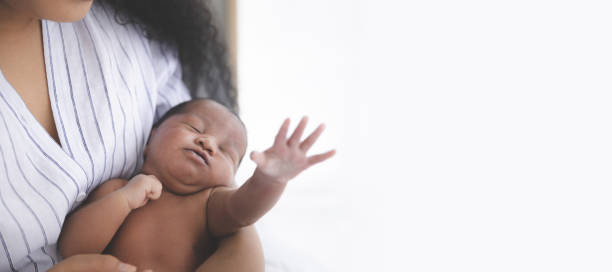 Newborn baby sleeping in the mother Close up of Mixed race black boy Ethnicity Thai-Nigeria. Newborn baby sleeping in the mother's embrace on the bed in home and nature sunlight with Copy space biracial newborn stock pictures, royalty-free photos & images