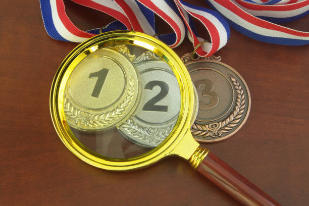 istock Gold, silver and bronze medal with magnifying glass. 1301326772