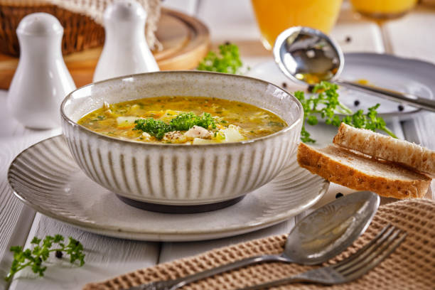 istock Chicken soup with crispy bread and orange juice on a white wooden table 1301328611