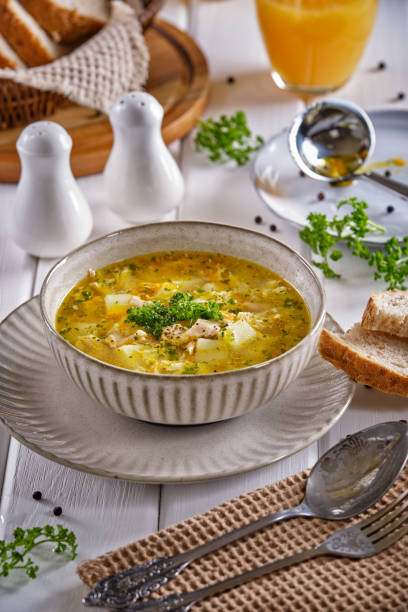 istock Chicken soup with crispy bread and orange juice on a white wooden table 1301328623