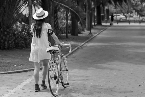 Girl carrying a bike on an autumn day down a desolate street