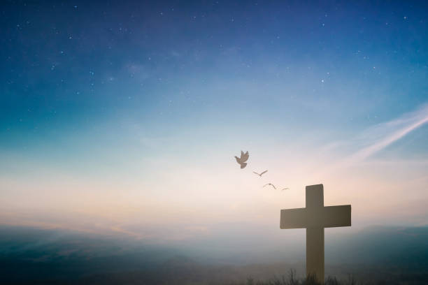Silhouette jesus christ crucifix on cross on calvary sunset background concept for good friday he is risen in easter day, good friday worship in God, Christian praying in holy spirit religious. stock photo