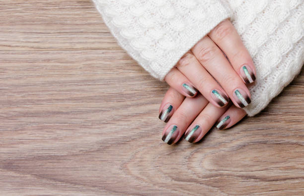 istock Female hands with black manicure on a wooden background. 1301338657