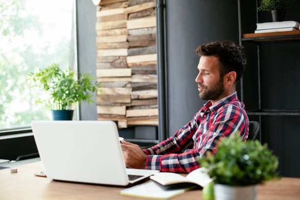 istock Young businessman using laptop and drinking coffee in his office. 1301347664