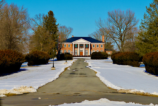 Boyce, Virginia / USA - February 8, 2021: Afternoon sun bathes historic Lockesly Manor as snow covers the grounds.