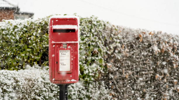 istock Red post box at Christmas covered with falling snow 1301350087