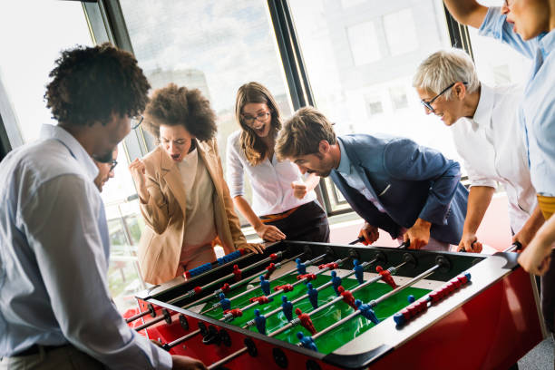 istock Employees playing table soccer indoor game in the office during break time 1301352477