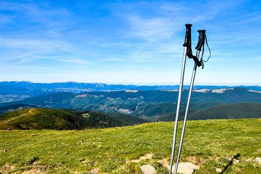 Trekking poles at top of mountain with beautiful view of autumn mountains. Natural background. Hiking. Travel goal concept