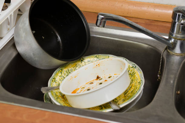 Dirty kitchen with dirty sink full of dishes. Photo of a sink full of dirty dishes