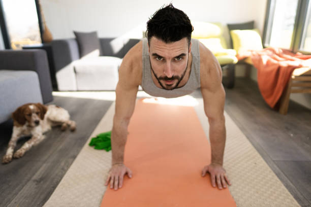istock Young athlete doing push ups on exercise mat in living room 1301355212