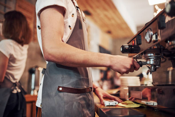 istock With machine. Two young cafe workers indoors. Conception of business and service 1301355679