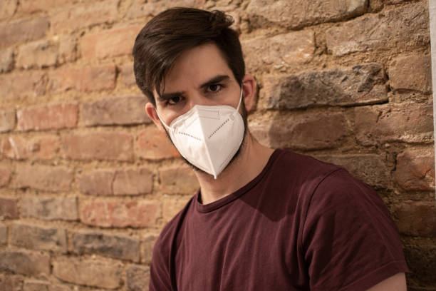 istock Man wearing FFP2 mask brick wall 1301357035