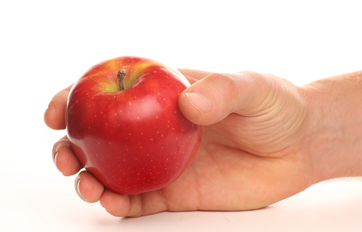Red apple in human hands as a symbol of healthy eating.