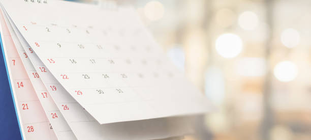cerrar calendario de escritorio de papel blanco con cita de fondo bokeh borrosa y concepto de reunión de negocios - calendario fotografías e imágenes de stock