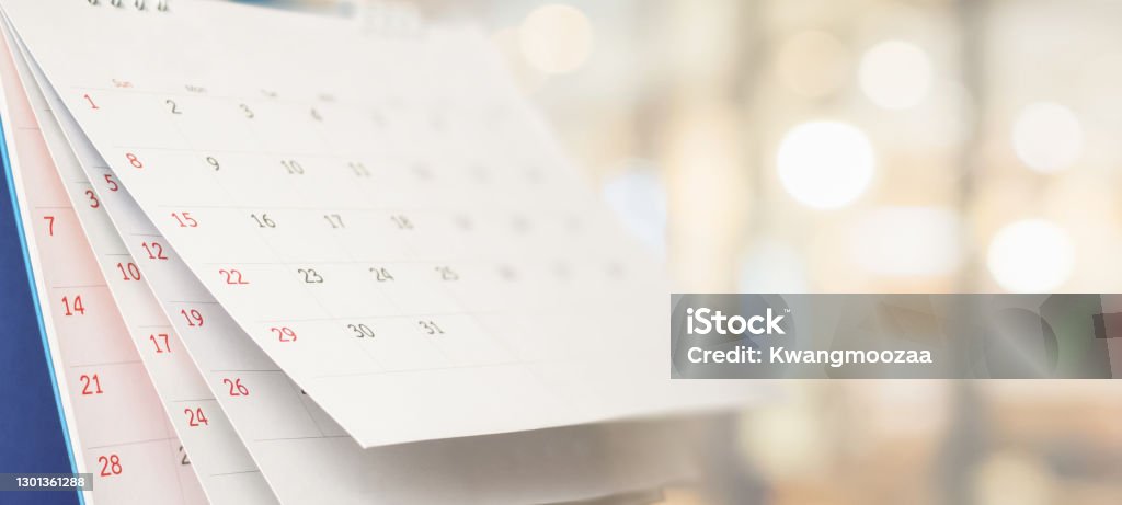 Close up white paper desk calendar with blurred bokeh background appointment and business meeting concept Calendar Stock Photo