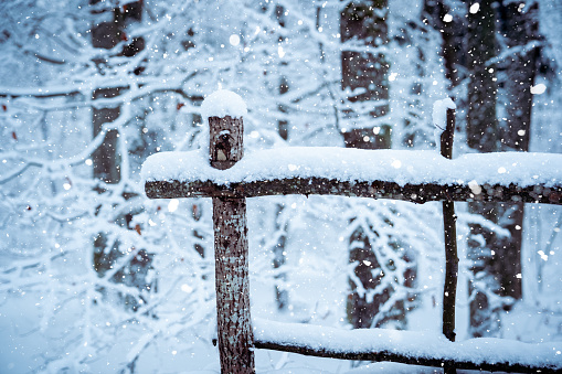 Winter christmas background - snow falling on wooden fence.