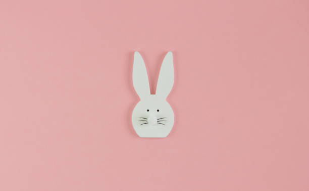istock White wooden bunny on a rose background 1301365020