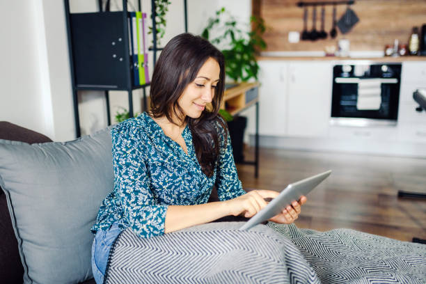 istock Smiling caucasian woman using a digital tablet stock photo. 1301365544