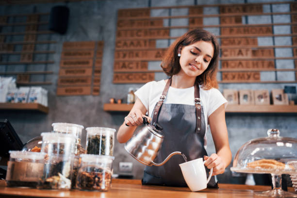 quand tu aimes ton travail. jeune ouvrier féminin de café à l’intérieur. conception des affaires et du service - premier emploi photos et images de collection