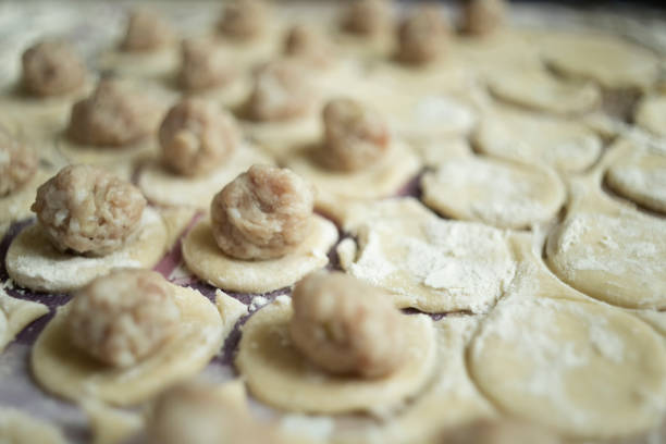 Woman making ravioli,pelmeni,manti or mant. Traditional Turkish patty stuffed with minced meat, dumplings.