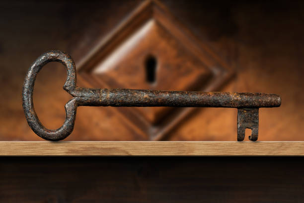 istock Old Rusty Key and a Wooden Keyhole on a Wood Shelf 1301366697